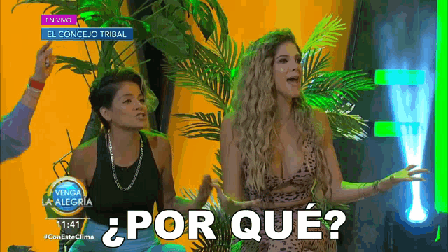 two women are standing in front of a sign that says ¿por que?