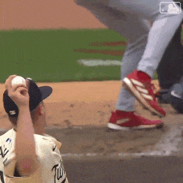 a baseball player in a twins uniform is holding a ball