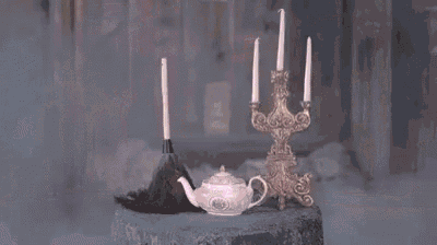 a candle is being lit in a room with smoke coming out of it and a candle holder .
