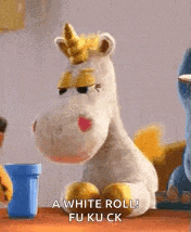 a stuffed unicorn from toy story is sitting on a table and talking to another stuffed animal .