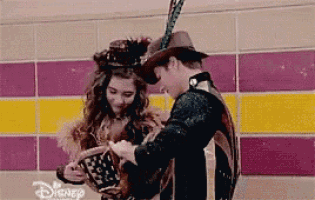 a man and a woman are standing next to each other . the man is wearing a hat .