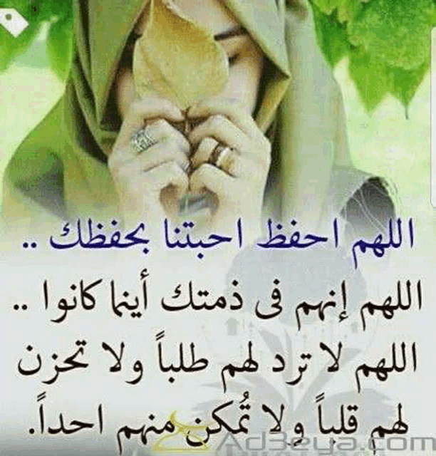 a woman in a hijab is holding a leaf in her hands with arabic writing behind her