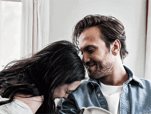 a man and a woman are looking at each other with their eyes closed