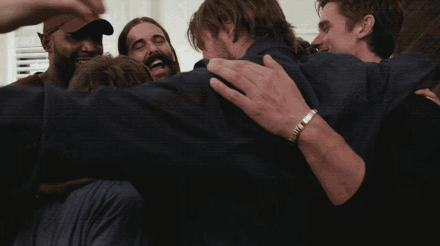 a group of men are hugging each other in a huddle