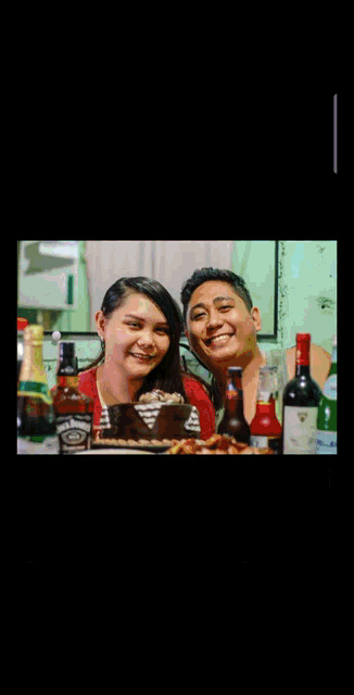 a bottle of jack daniels sits on a table next to a woman