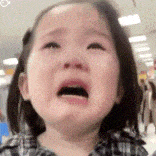 a little girl is crying with her mouth open and her eyes closed .