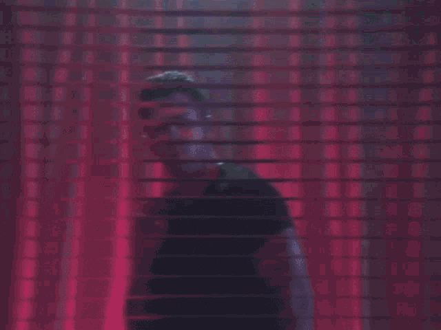 a close up of a man 's face behind blinds .