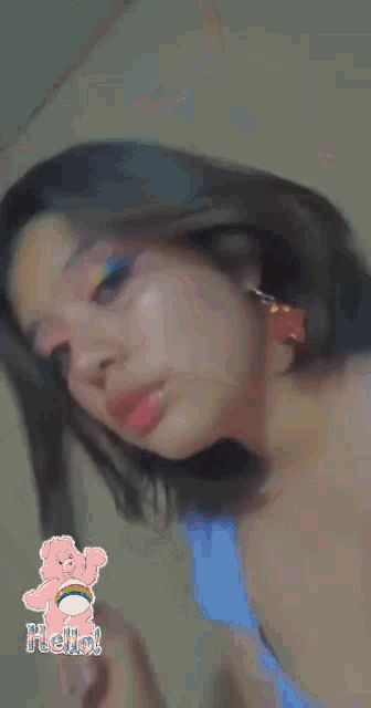 a close up of a woman 's face with a care bear sticker in the background