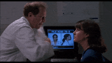 a man and a woman are looking at a screen that says file xc86-79-s on it