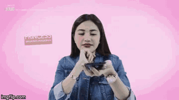 a woman in a denim jacket is holding a cell phone and the word princess is on the screen behind her
