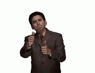 a man in a suit and tie is giving a thumbs up while holding a bottle .