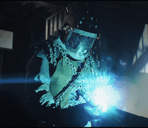 a man wearing chains around his neck is welding
