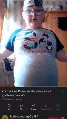 a boy wearing glasses and a cherubino shirt is standing in front of a wall
