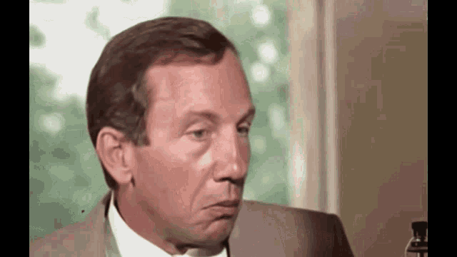a man in a suit and tie making a face