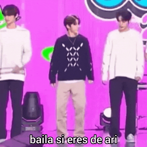 a group of men are standing next to each other on a stage in front of a purple background .