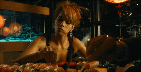 a woman with red nail polish is licking a piece of food