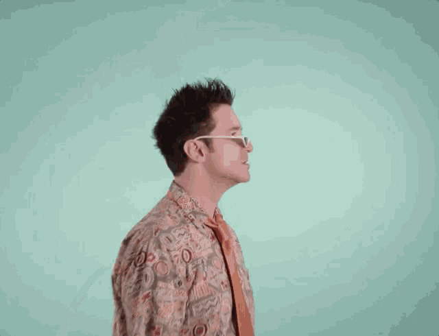 a man wearing sunglasses and a shirt with a pattern that says ' a ' on it