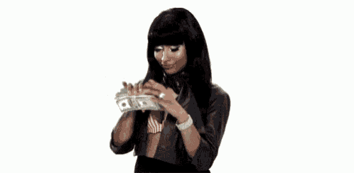 a woman is holding a bunch of money in her hands and looking at it .
