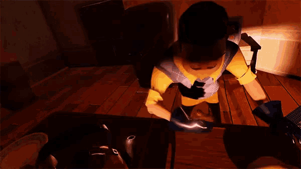 a man in a yellow shirt is sitting on a wooden table