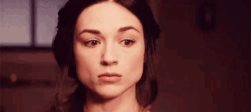 a close up of a woman 's face with a serious expression .