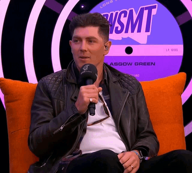 a man sitting in front of a sign that says wsmt on it