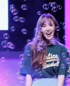 a girl wearing a green shirt that says ' oakland baseball '
