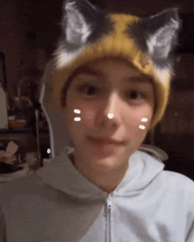 a person wearing a cat eared hat and a white hoodie