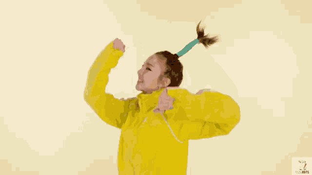 a woman in a yellow jacket is making a funny face with her arms outstretched