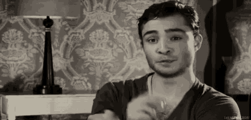 a man is sitting in a room with his arms crossed .