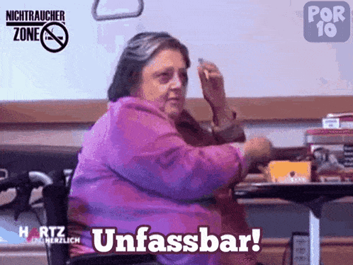 a woman in a wheelchair is sitting at a table with the words unfassbar on the bottom