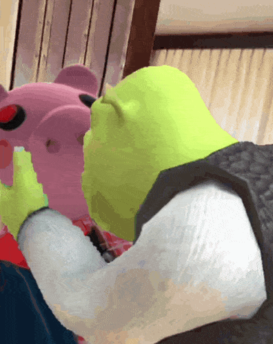 shrek kissing a pink piggy bank with a red button