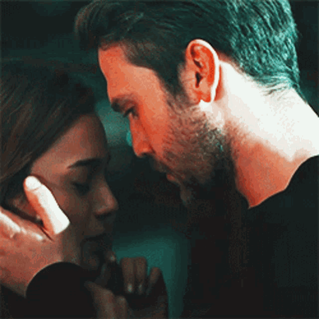 a man touching a woman 's face with his hand