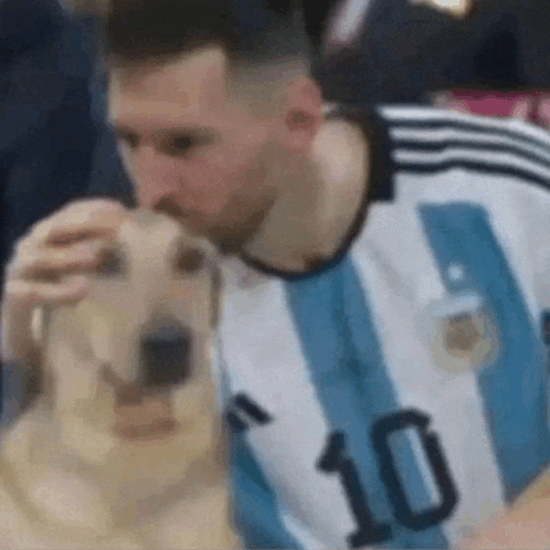 a man in a blue and white striped shirt with the number 10 on it is petting a dog .