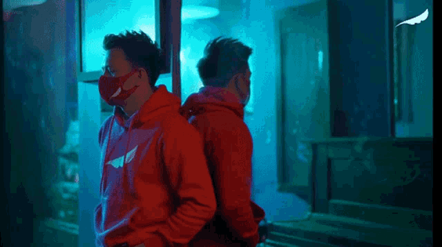 a man in a red hoodie wearing a mask