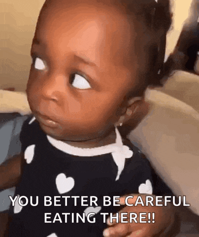 a baby girl is making a funny face and says `` you better be careful eating there ! ''