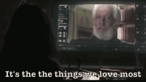 a man with a beard is looking at a screen with the words it 's the things we love most