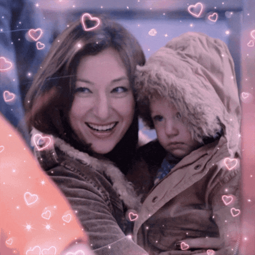 a woman holds a child in her arms with pink hearts surrounding them