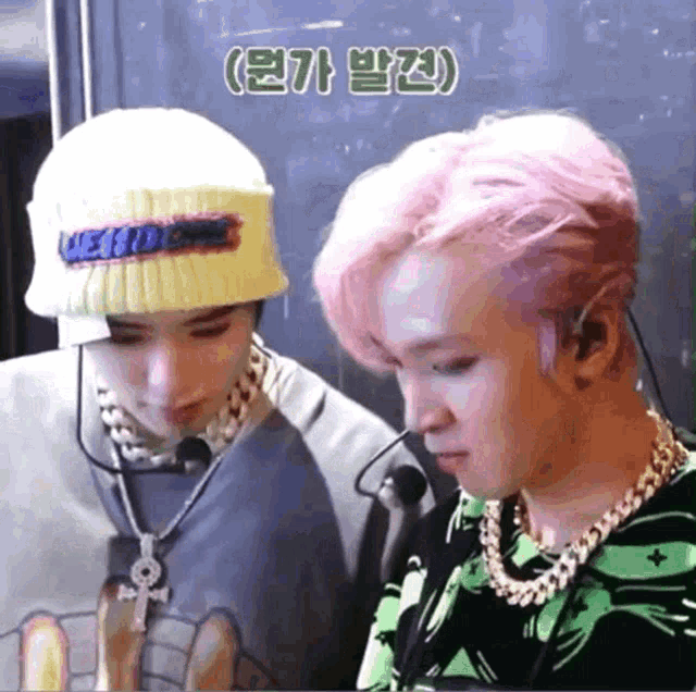 a man with pink hair is wearing a yellow hat that says " we are one " on it