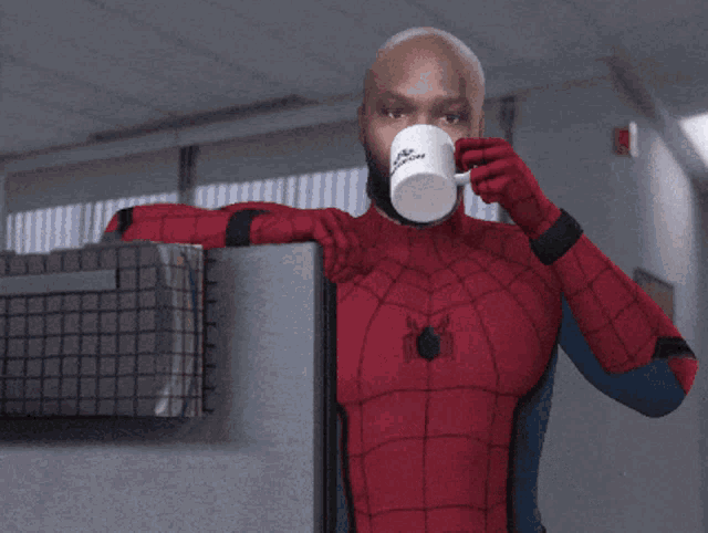 a man in a spiderman costume holds a mug that says intech on it