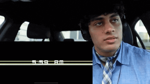 a man wearing headphones sitting in a car next to a screen that says thansk