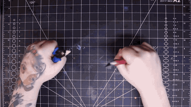 a person with a tattoo on their arm is working on a cutting mat that says 25x17 inch on it