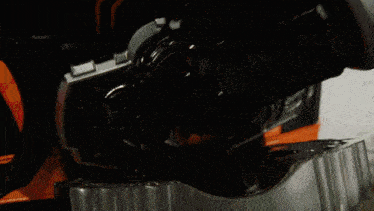 a close up of a metal object with a black and orange stripe on it