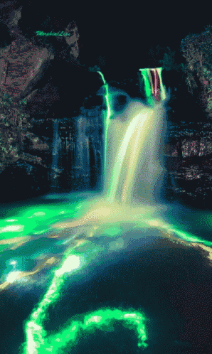 a waterfall is lit up with green and red lights and the number 6 is visible