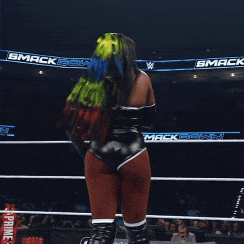 a woman stands in a wrestling ring with the word gatorade on her sleeve