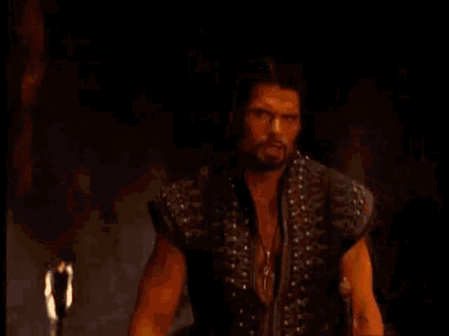 a man with a beard stands in the dark and says " is that any way to request the company of your patron god ? "