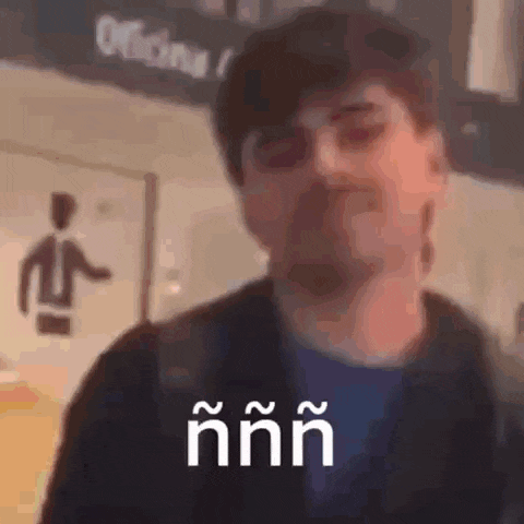 a man with a beard is making a funny face in front of a sign that says oficina .
