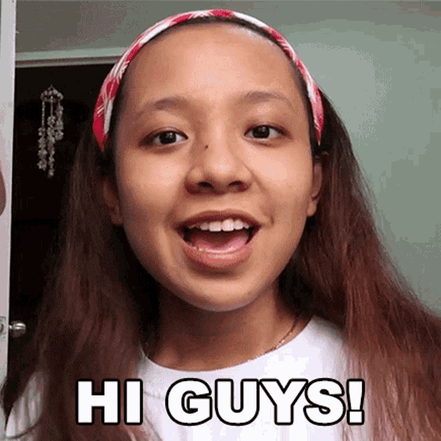 a girl wearing a headband and a white shirt is saying hi guys