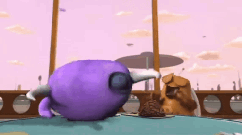 a purple monster with horns is standing on a table next to a brown monster .