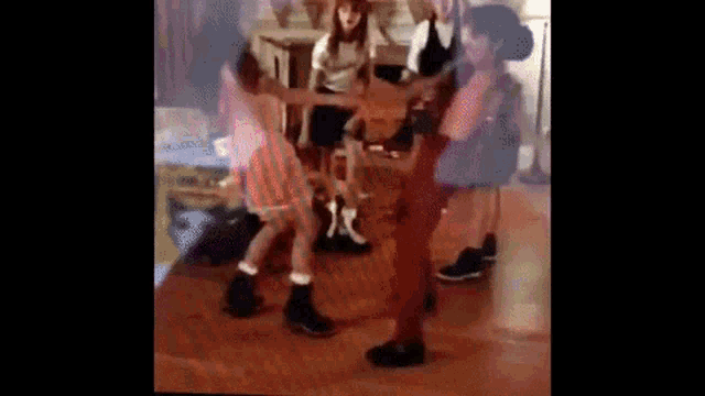 a group of people are dancing on a wooden floor .