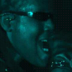 a man wearing sunglasses is smoking a cigarette in the dark